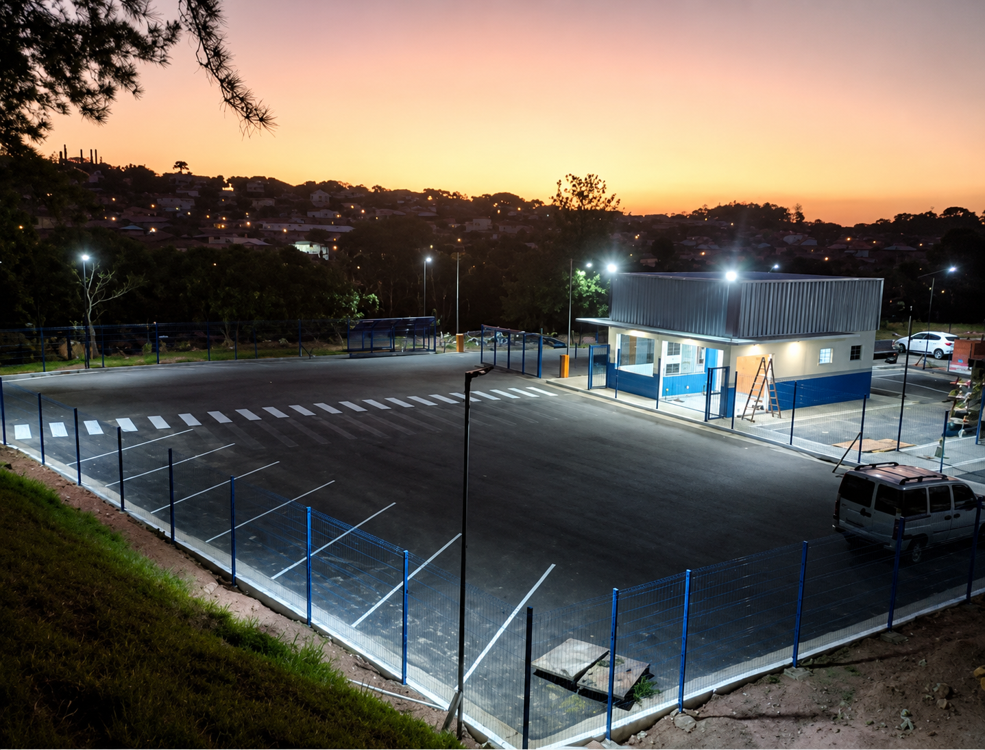 Portaria, pavimentação e balança rodoviária na Saint-Gobain — obra da Sage ao entardecer